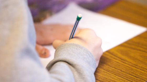 person writing on a piece of paper